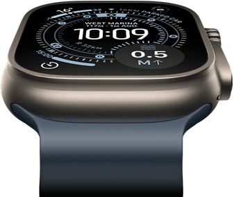 Pochylony do przodu Apple Watch Ultra 3 z kopertą z tytanu w kolorze naturalnym, widać kompas na tarczy Orienteering, zegarek ma pasek Ocean w kolorze marynarskiego granatu