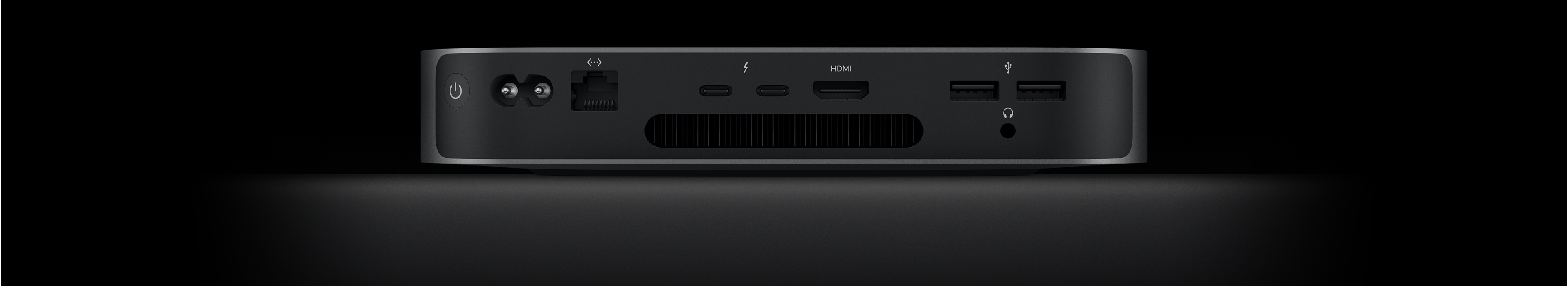 Widok Maca mini z tyłu: dwa porty Thunderbolt 4, port HDMI, dwa porty USB‑A, gniazdo słuchawkowe, port Gigabit Ethernet, gniazdo zasilania i przycisk zasilania.